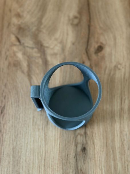 Blauer Becher mit Henkel auf einem Holzuntergrund.